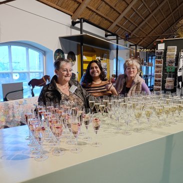 Vrijwilligers en medewerker staan klaar met de bubbels