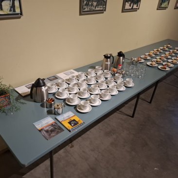 Tafel met koffie en oranjekoek in de presentatiezaal