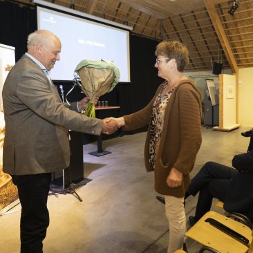 Voorzitter Kooistra overhandigt een bos bloemen aan mevrouw Adema