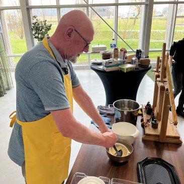 Vrijwilliger laat zien hoe kaas gemaakt wordt tijdens een workshop bij Dairy Campus