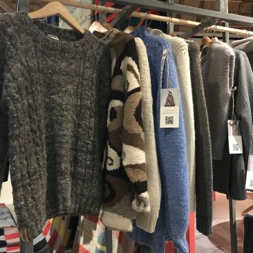 Rek met gebreide wollen truien in de expositie