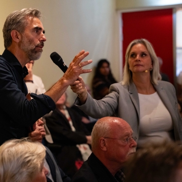 Een bezoeker uit het publiek stelt een vraag aan het panel tijdens een debat onder leiding van Esther de Snoo