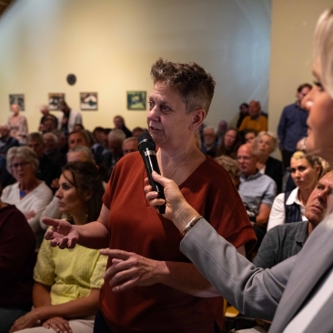 Een bezoeker uit het publiek stelt een vraag aan het panel tijdens een debat onder leiding van Esther de Snoo