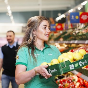 Lidl medewerker loopt met een doos citroenen waarop de woorden "Bio" en "Organic" staan