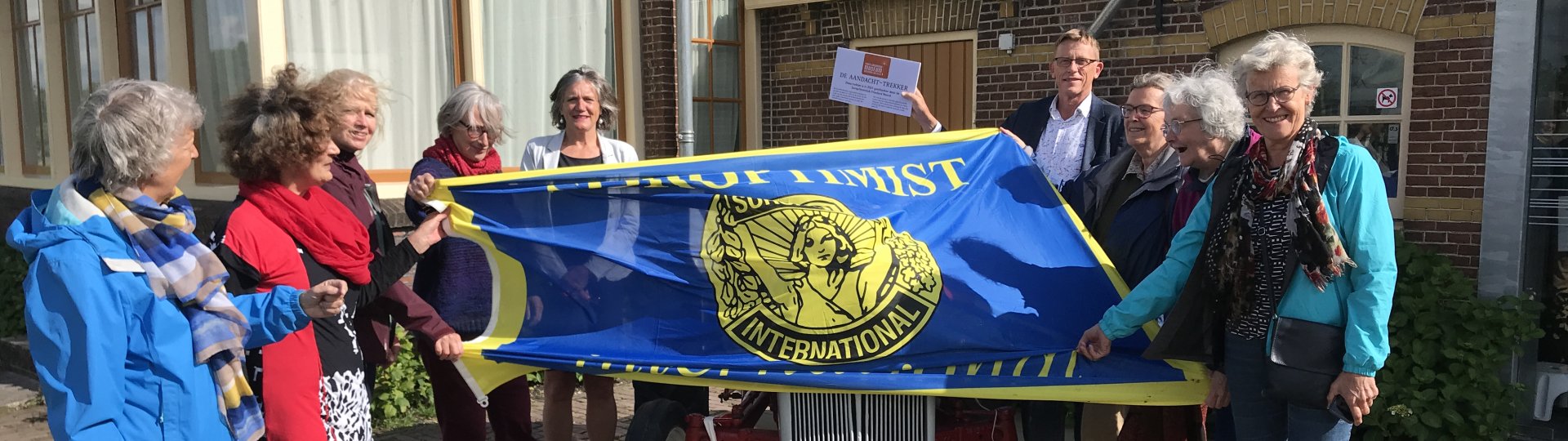 Soroptomisten en directeur Henk Dijkstra bij de geschonken trekker voor het museum