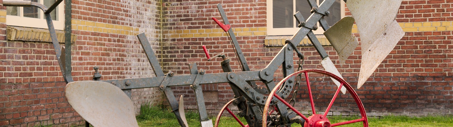 Kiepploeg op het terrein voor de monumentale boerderij