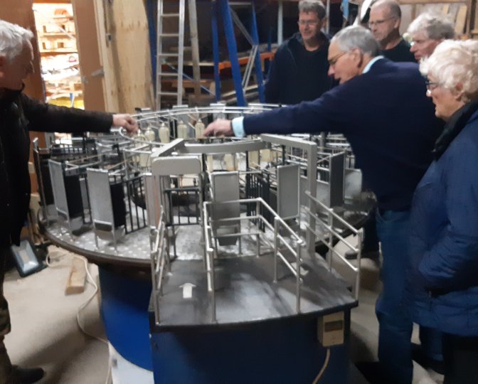 Vrijwilligers bij het schaalmodel van de draaimelkstal