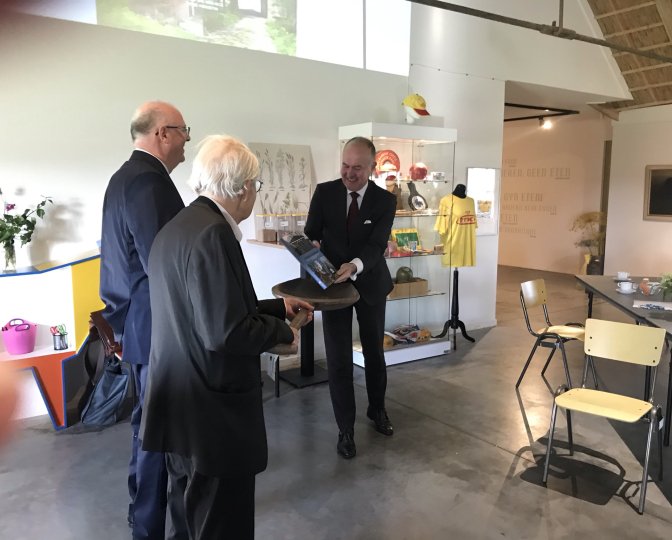 Overhandiging boek 'Cultureel erfgoed op it Fryske boerehiem' aan commissaris van de koning Arno Brok in de foyer van het Fries Landbouwmuseum