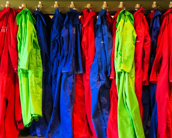 Overalls in verschillende kleuren en maten aan een kapstok
