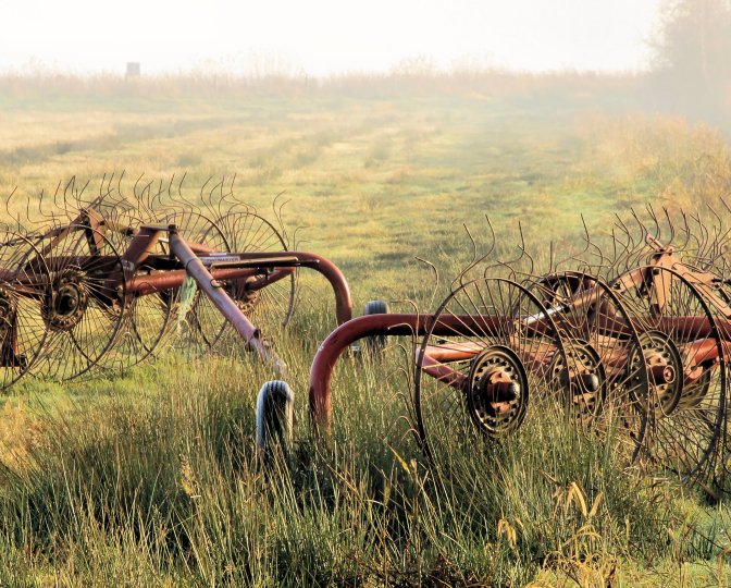 Landbouwwerktuigen in een weiland, foto door Sytze Herder